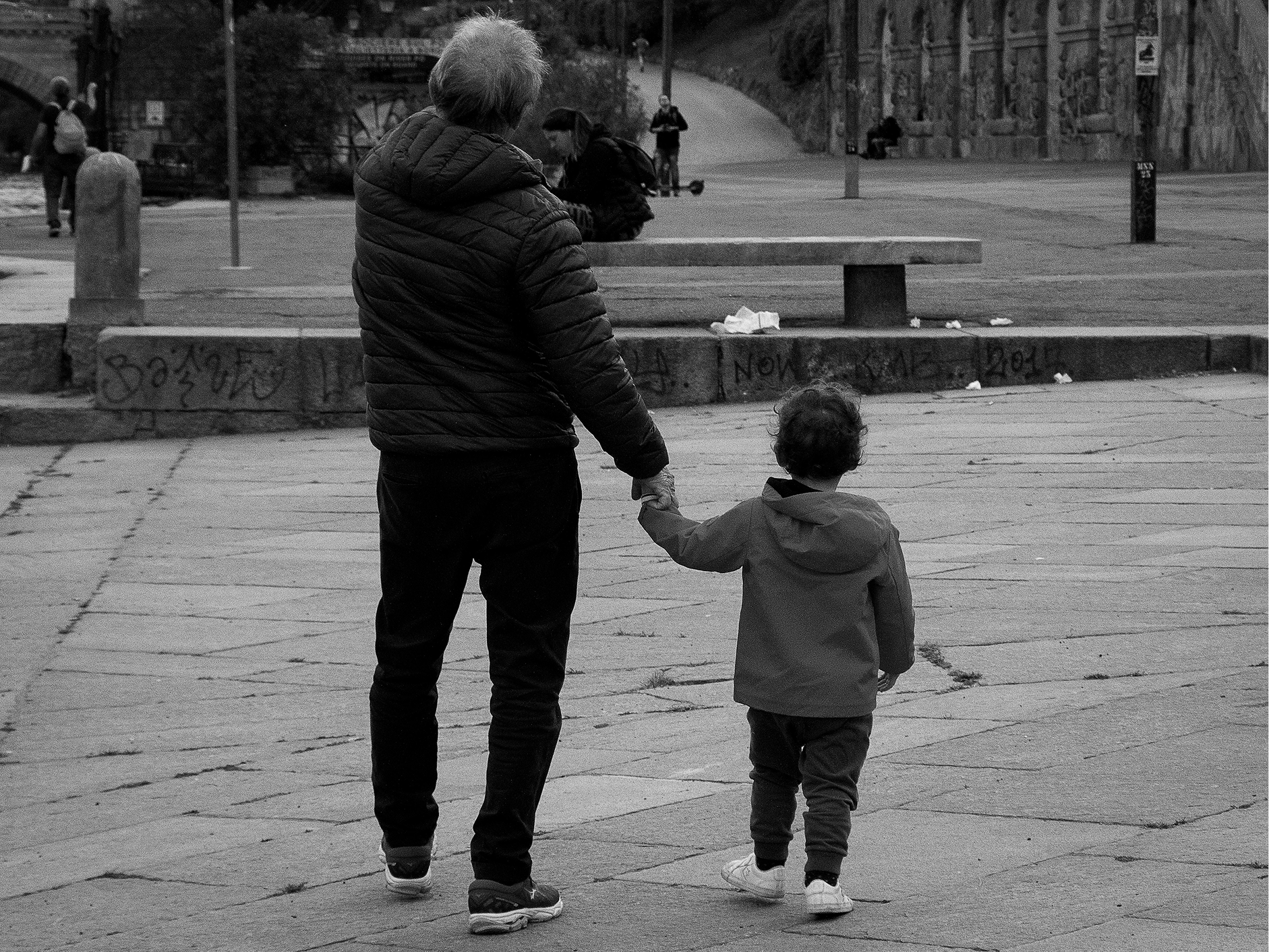 Grandpa and grandchild holding hands outside